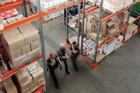 Three men walking in a warehouse